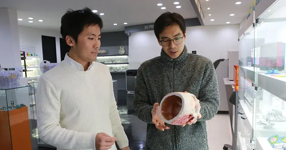 2 Kollegen schauen auf einen 3D-Druck