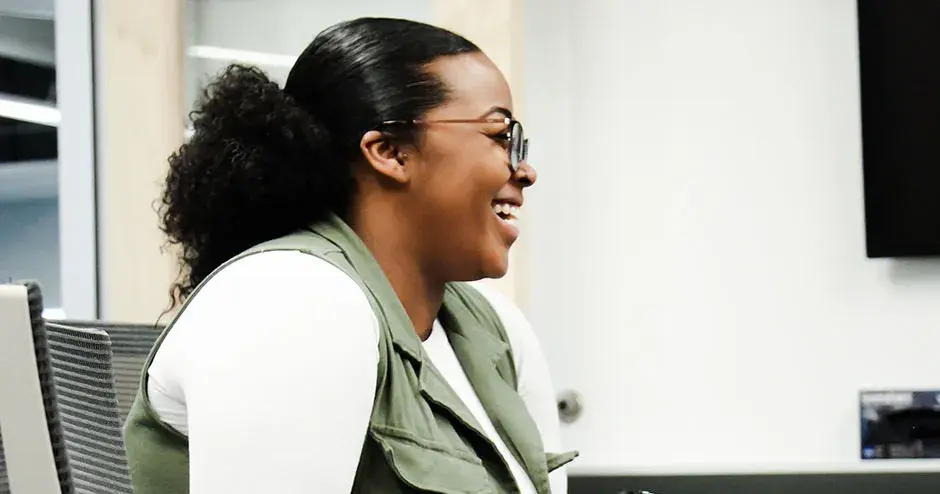 ein Kollege, der an einem Tisch sitzt und lächelt