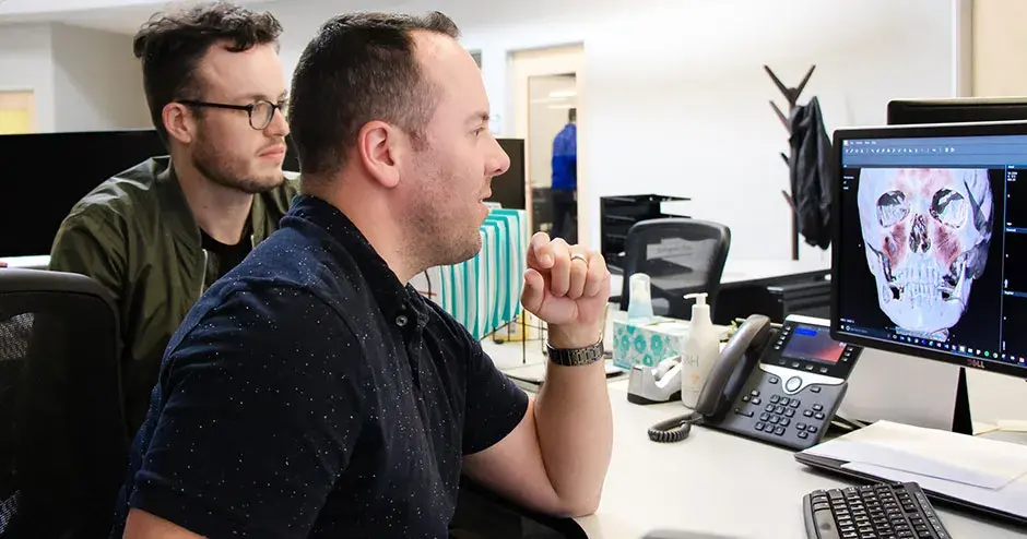 2 Kollegen an einem Schreibtisch