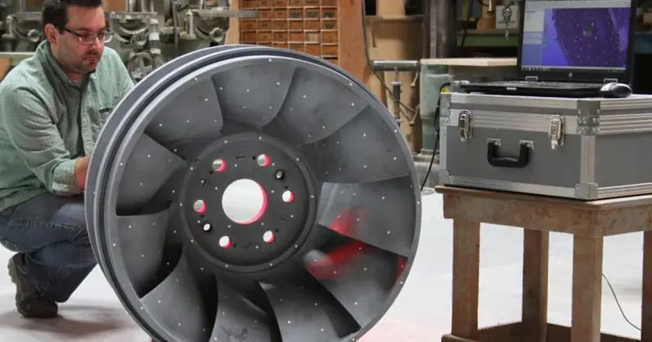 eine Person, die neben einem Feingussteil in einer industriellen Umgebung steht