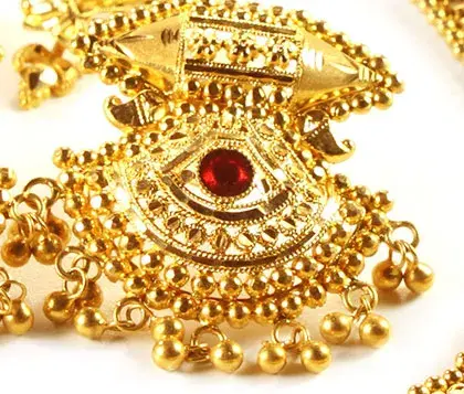 filigranes ohrring-design aus gold mit einem in der mitte gesetzten rubin