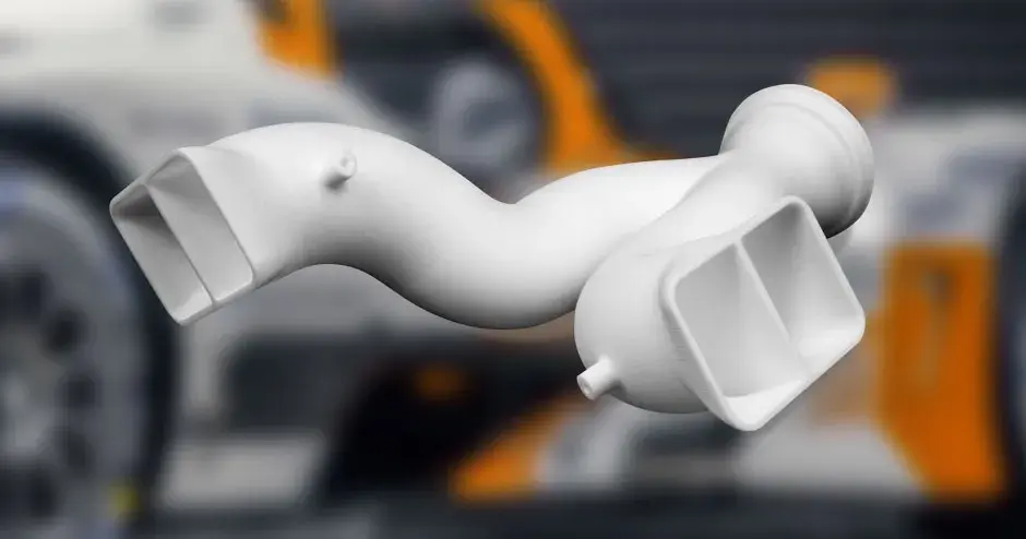 3D-gedrucktes Krümmerteil aus White SLS mit Hintergrund