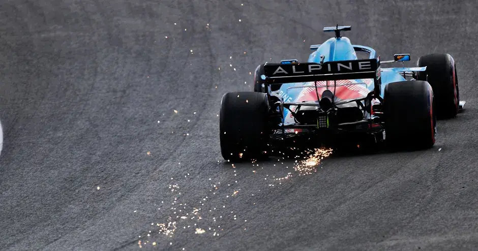 alpine f1 rennwagen unterwegs auf der rennstrecke, funken sprühen am fahrzeugheck