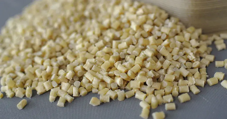 Grauweiße Plastikpellets vor grauem Hintergrund