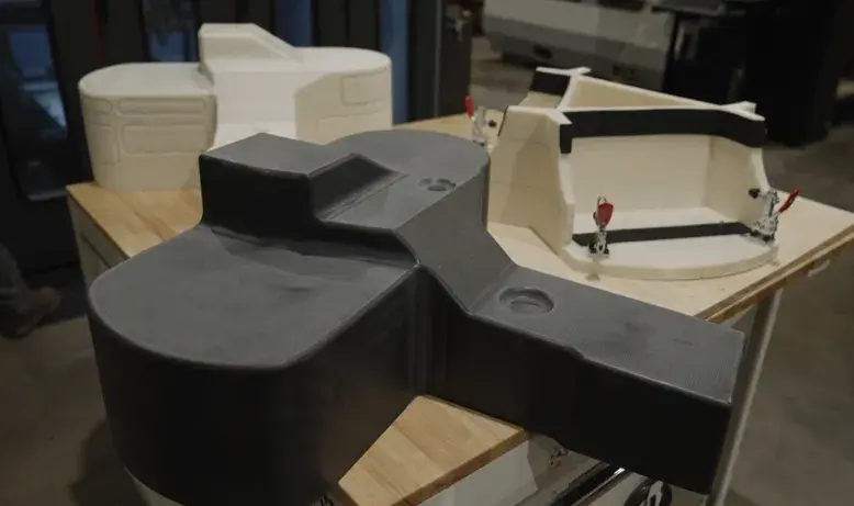 Eine 3D-gedruckte und maschinell bearbeitete CF-PC-Thermoform, ein 3D-gedruckter ABS-Prototyp eines Formteils und eine 3D-gedruckte ABS-Verkleidungsvorrichtung, die alle auf dem EXT 1270 Titan Pellet von 3D Systems hergestellt wurden. 